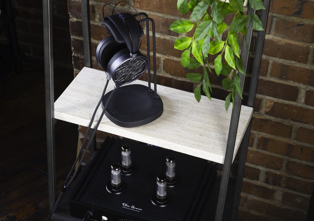 Dan Clark Audio Corina headphone on stand with Blue Hawaii amp and brick background