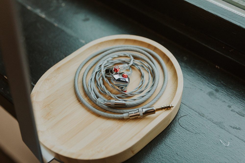 Dunu titan s2 iem coiled sitting on wooden headphone stand