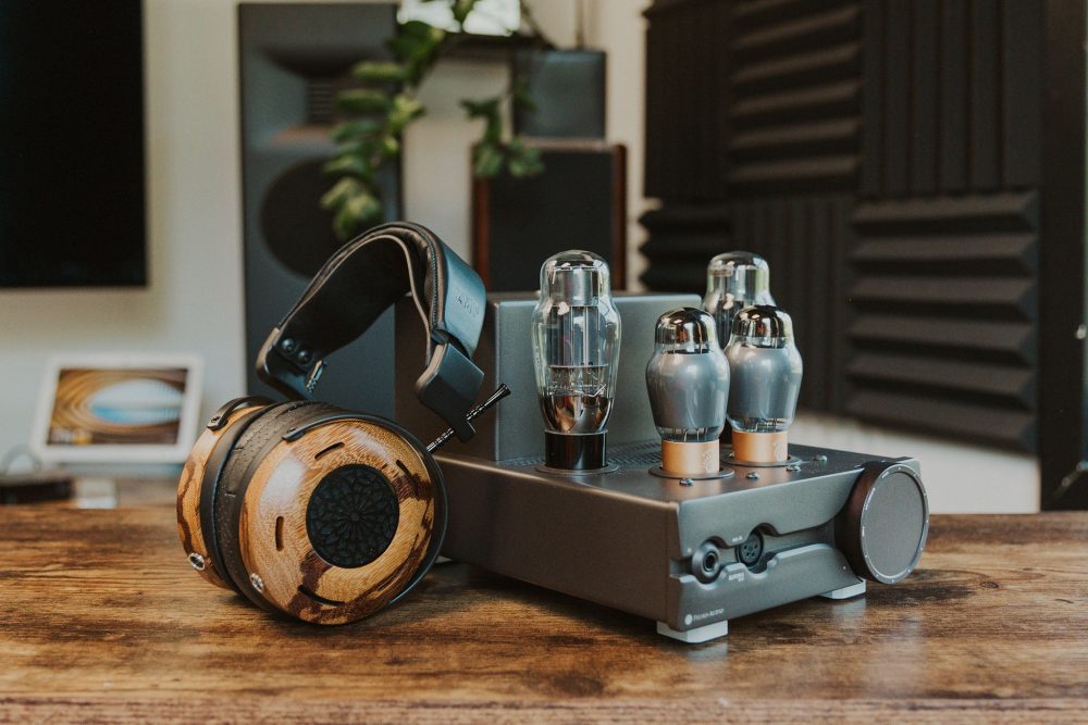 Feliks audio euforia evo sitting on wooden table with headphone leaning on side