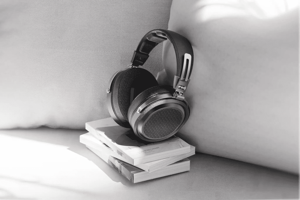 FiiO FT1 Pro headphones sitting on stack of books on grey couch