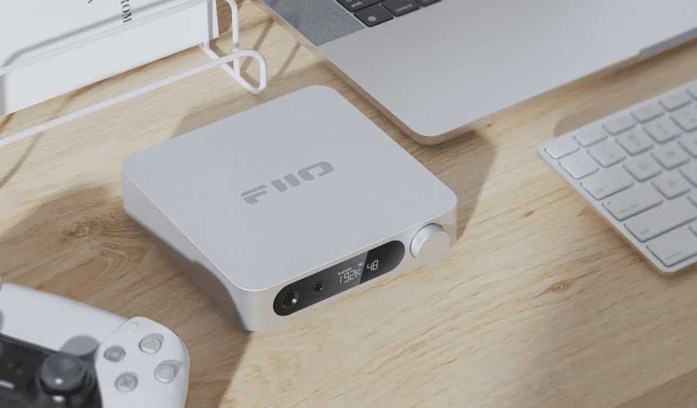 FiiO K11 dac/amp white sitting on wooden desk with laptop and game controller