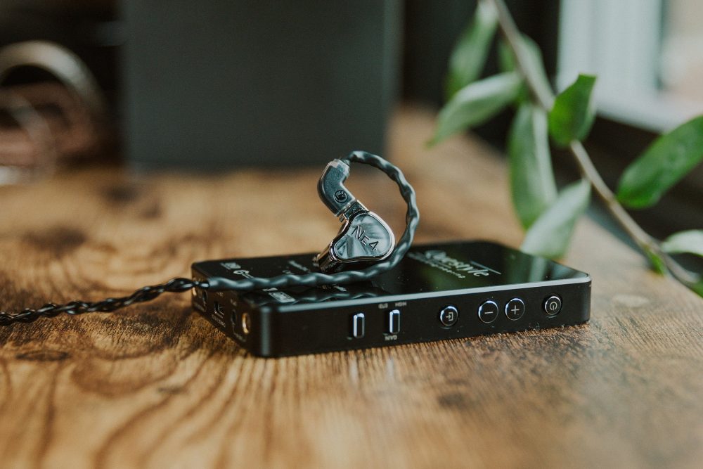 fir audio neon4 iem sitting on questyle dac on wooden table