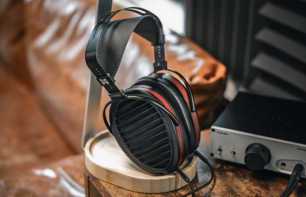 HiFiMAN Arya Organic on headphone stand with Amp next to leather couch from Bloom Audio gallery