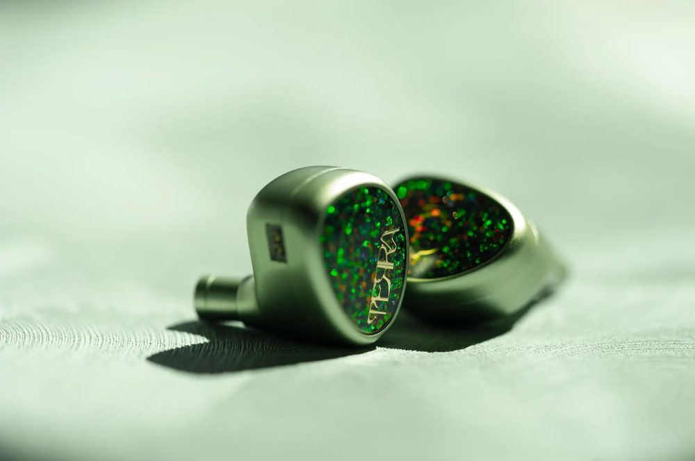 Lime Ears Terra IEMs sitting on green background