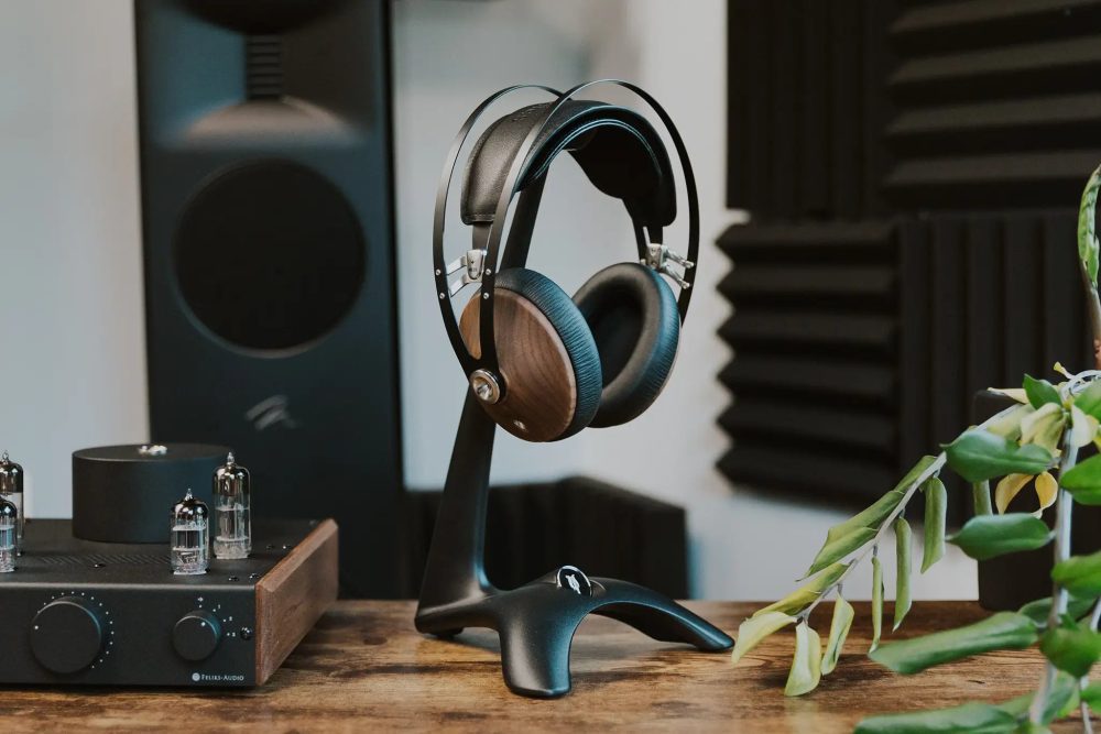 Meze 99 Classics sitting on manta headphone stand on wooden table with tube amp