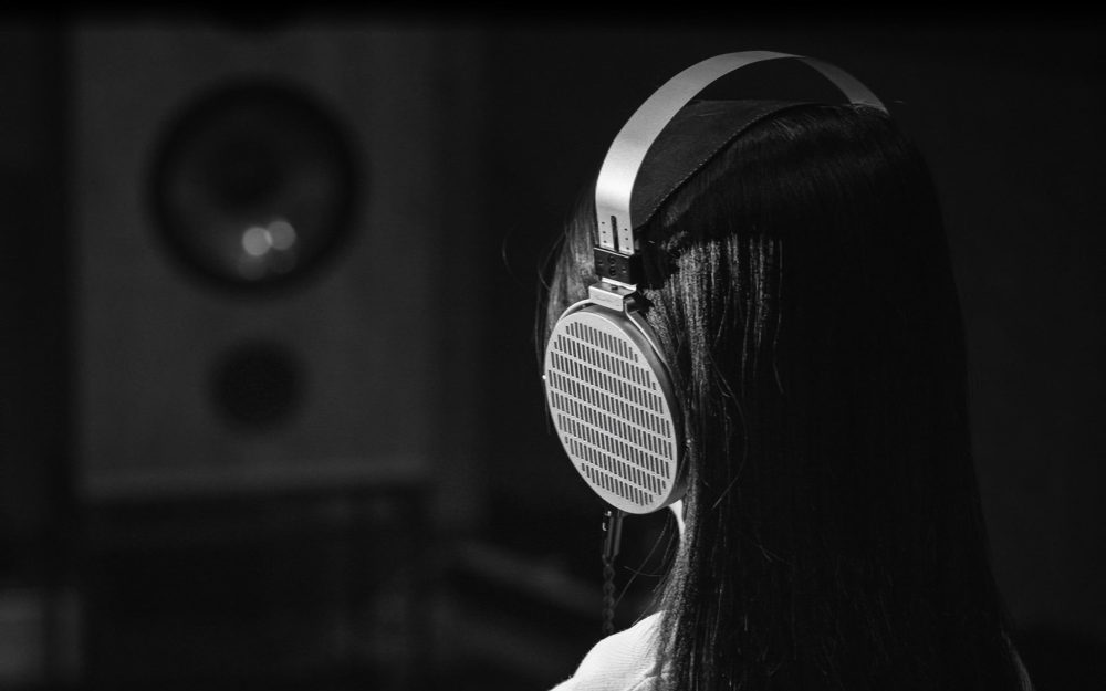 human facing bookshelf speaker wearing Cosmo headphones