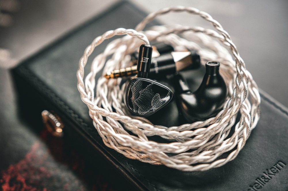 Noble Onyx earphones aith attached coiled Eletech Courage cable on top of Astell&Kern audio player