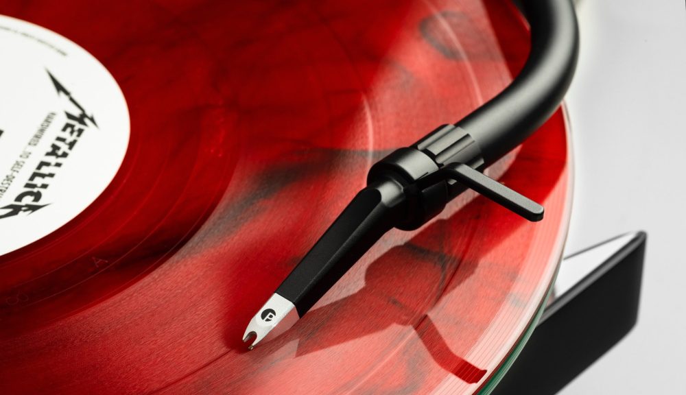 Pro-Ject Metallica turntable closeup tonearm with red vinyl on platter