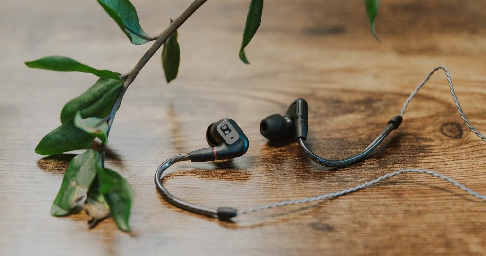 Sennheiser IE 200 earphones with attached stock cable  on wood table with plant