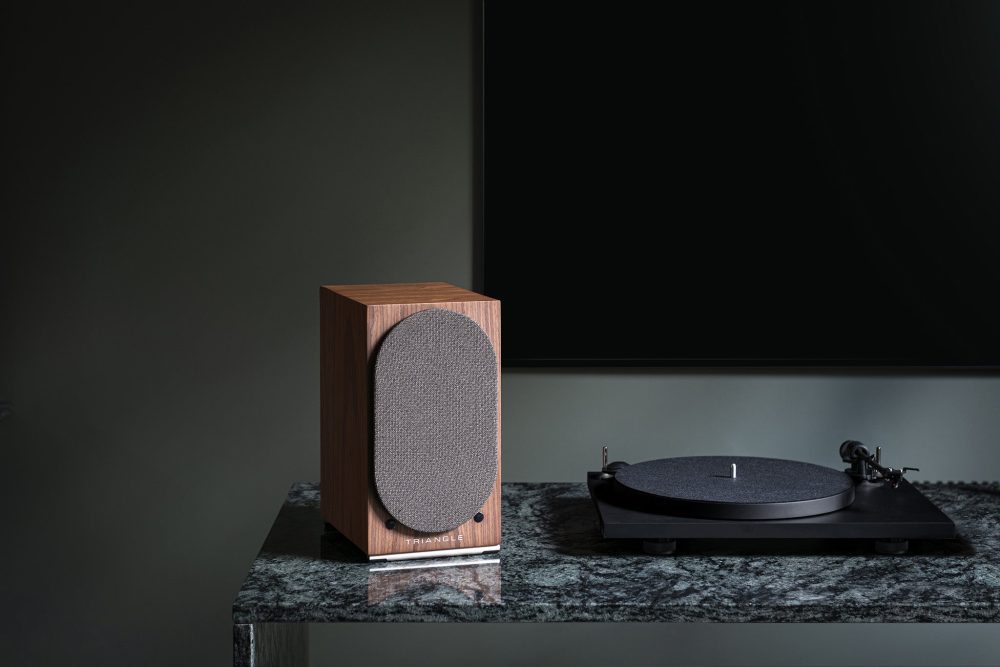 Triangle audio AIO Twin speaker sitting on black marble table with vinyl record player