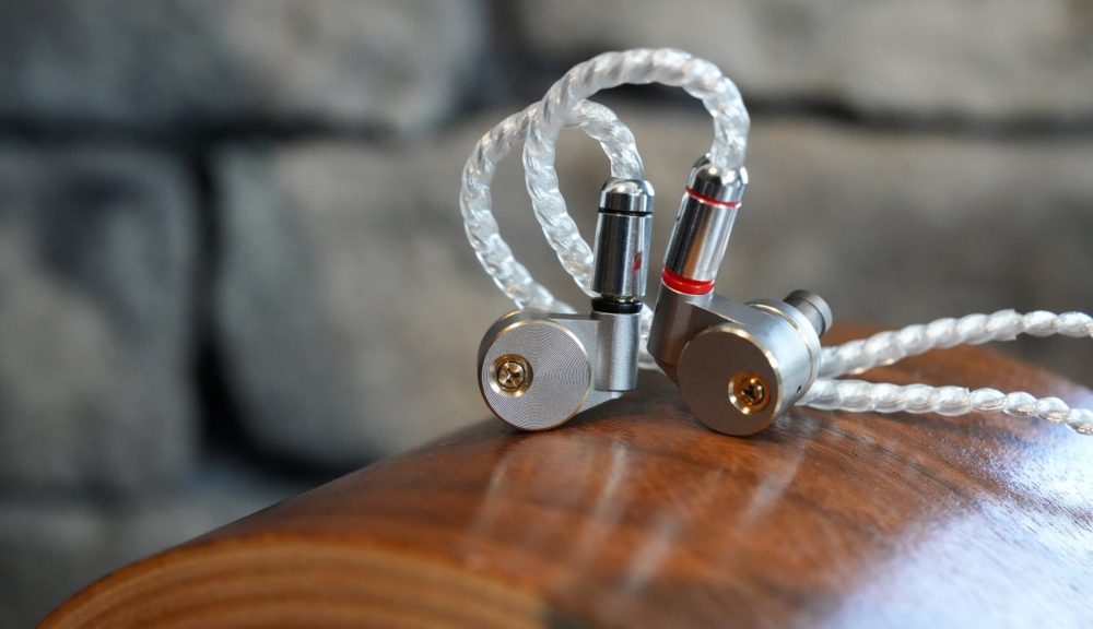 Ucotech RE-2 earphones on top of wood stand with attached cable from Bloom Audio gallery